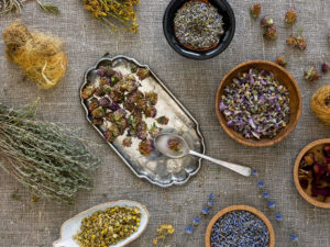 imagem de cima mostrando uma mesa com diversas ervas, como camomila e lavanda. As plantas possuem energia fitoenergética.