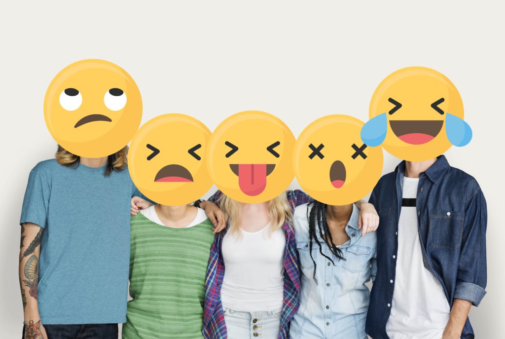 Emojis com emoções diversas foram colocados no lugar das cabeças das pessoas que se juntaram para tirar a foto